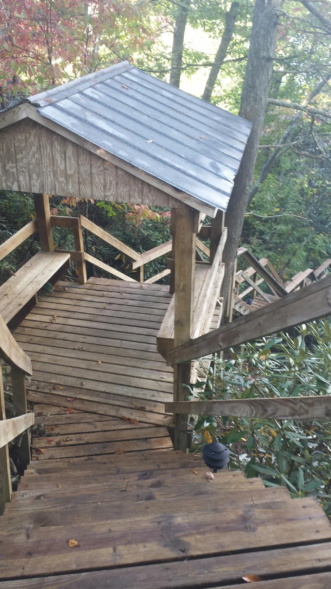 Metal roofed shelter over wooden steps on a wooded walkway — Skylight Repair & Installation work by our crew in East Chicago