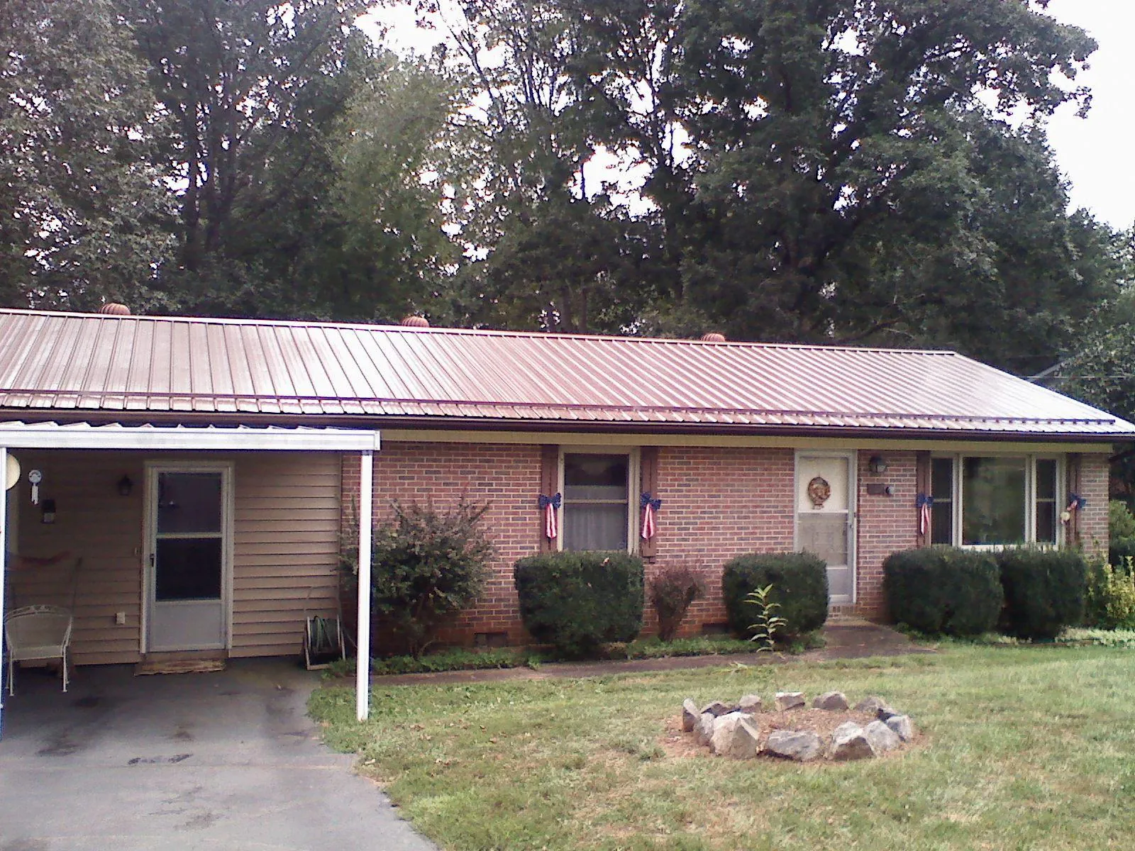 Bronze metal roof and carport on a brick ranch home — Roof Repair work by our crew in East Chicago